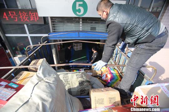 資料圖：工作人員正在給快遞包裹裝車。張?jiān)啤z